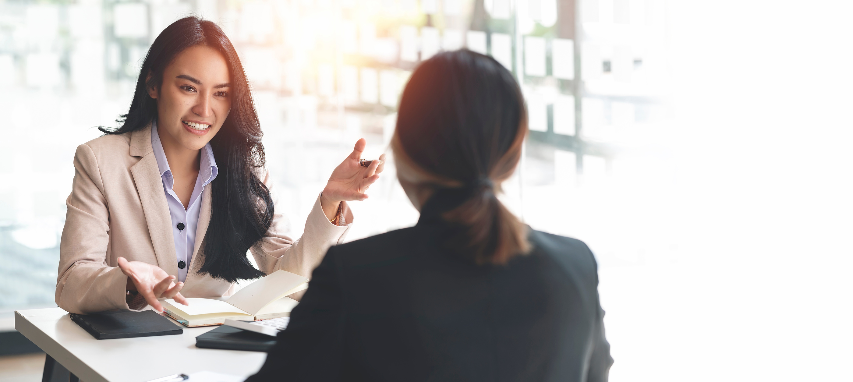 Two business people talking and discssing together sitting at desk